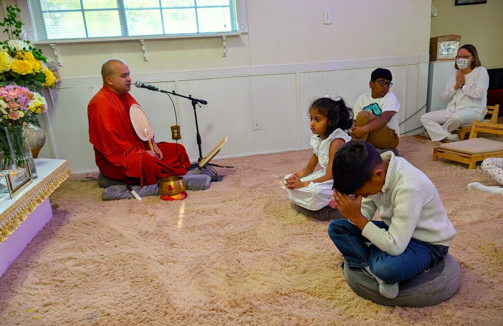 Dhamma School students worshipping and listening to a monk’s sermon in the Dhamma Sala.