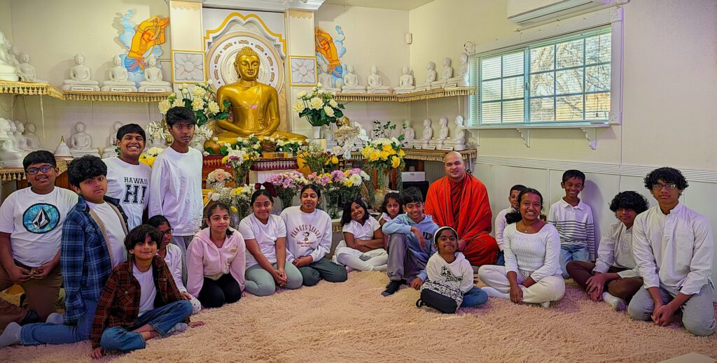 Chief Monk, volunteer teachers, and Dhamma School students gathered by the Buddha statue in the Austin Buddhist Vihara Dhamma Sala.